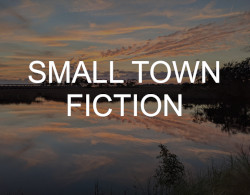 "Small Town Fiction" over a photo picturing a sunset reflected in a large inlet, surrounded by marsh